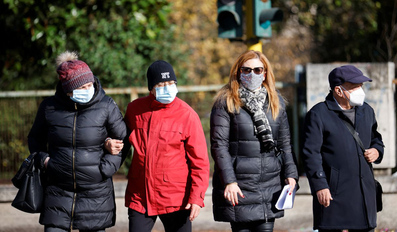 People wearing face masks walk in the street